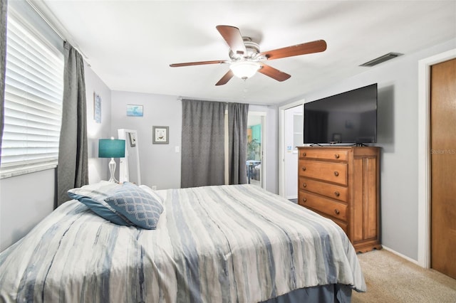 carpeted bedroom featuring multiple windows and ceiling fan