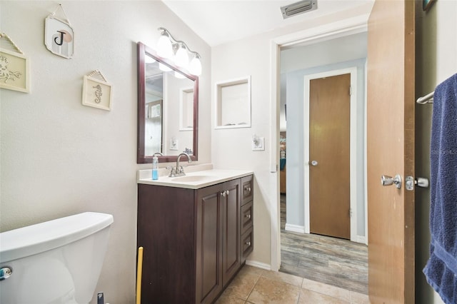 7511 Tyson Dr, Port Richey, FL 34668 - half bath featuring toilet, vanity, tile patterned flooring, and baseboards
