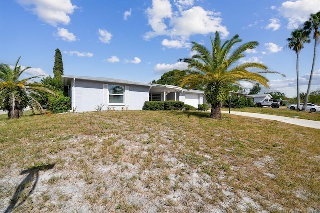 7511 Tyson Dr, Port Richey, FL 34668 - view of front of home with an attached garage, driveway, and stucco siding