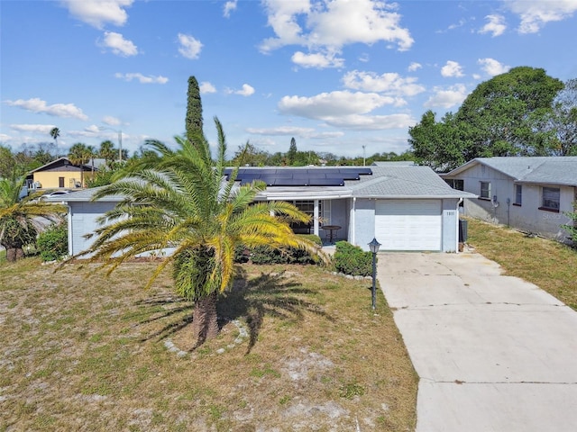 view of front of property with solar panels, a front lawn, and a garage