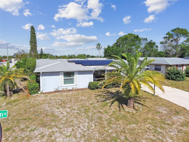 7511 Tyson Dr, Port Richey, FL 34668 - ranch-style house featuring roof mounted solar panels and stucco siding