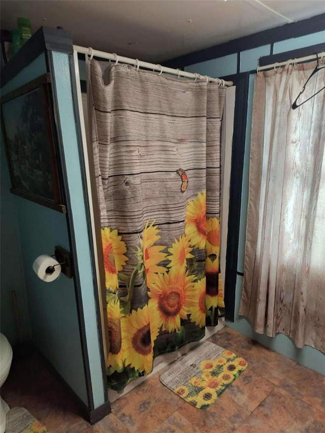 bathroom with curtained shower and toilet