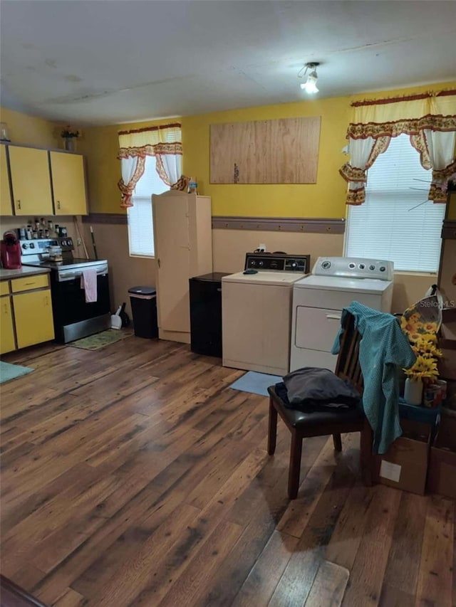 kitchen featuring separate washer and dryer, dark hardwood / wood-style flooring, and stainless steel electric range oven