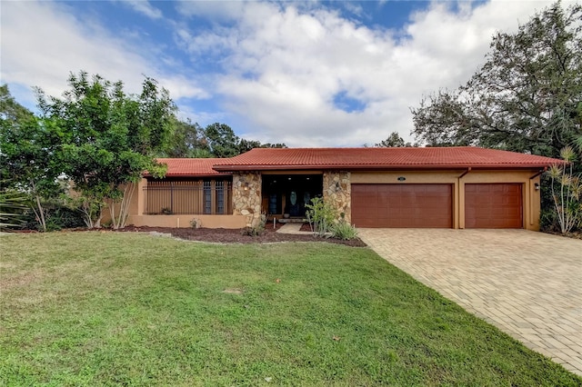 ranch-style house with a garage and a front lawn