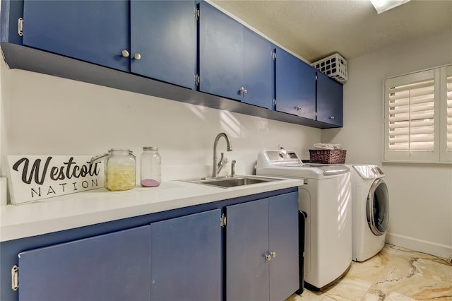 washroom with cabinets, washing machine and dryer, a textured ceiling, and sink