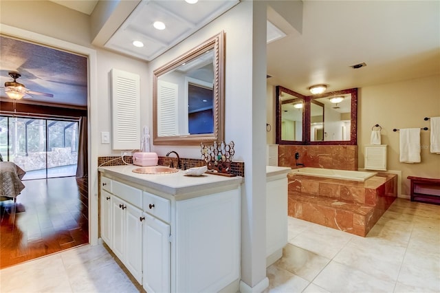 bathroom featuring a relaxing tiled tub, hardwood / wood-style flooring, ceiling fan, and vanity