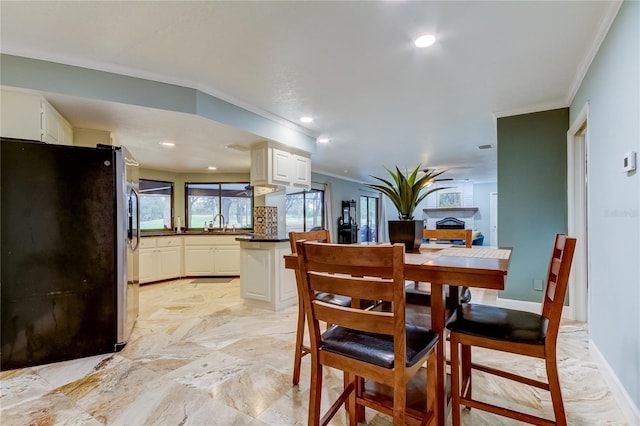 dining space featuring sink and ornamental molding