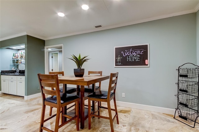 dining area with wet bar and crown molding