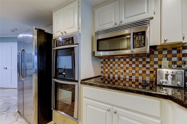 kitchen featuring white cabinetry, stainless steel appliances, and backsplash