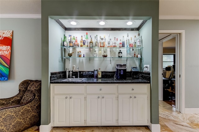 bar featuring white cabinetry, ornamental molding, sink, and dark stone counters