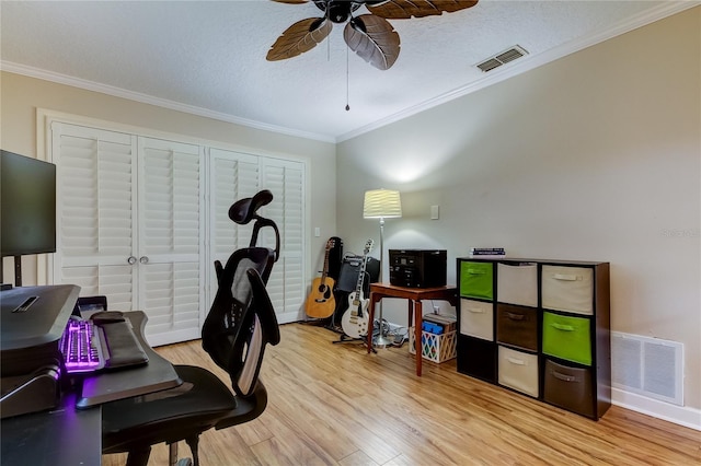 office area with a textured ceiling, light hardwood / wood-style flooring, ceiling fan, and crown molding