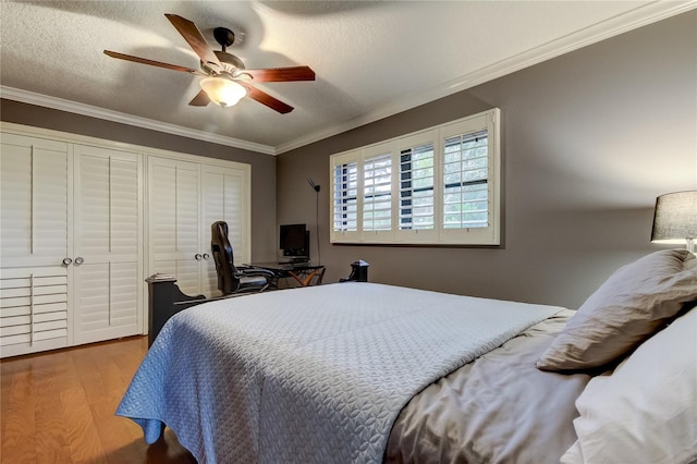 bedroom featuring light hardwood / wood-style floors, a textured ceiling, ceiling fan, and crown molding