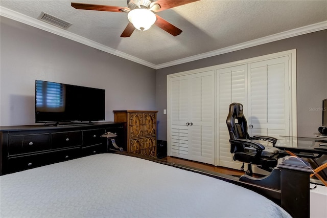 bedroom featuring a closet, a textured ceiling, ceiling fan, and crown molding