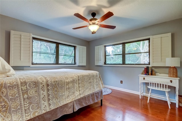 bedroom with a textured ceiling, hardwood / wood-style flooring, and ceiling fan