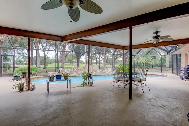 unfurnished sunroom featuring ceiling fan and a pool