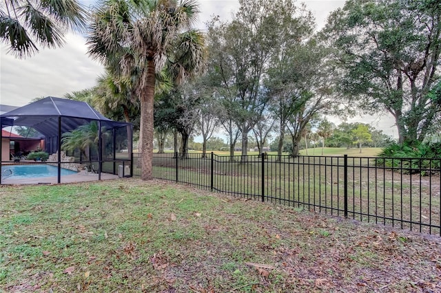 view of yard with a fenced in pool and glass enclosure