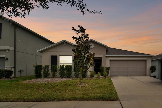 view of front of property with a garage and a yard