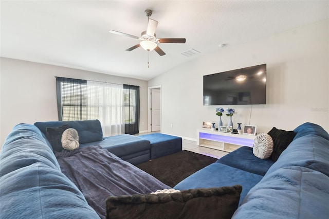 living room with ceiling fan, light tile patterned floors, and lofted ceiling