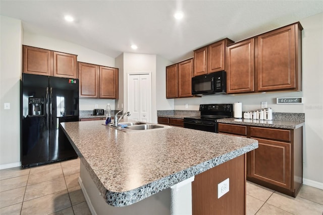 kitchen with black appliances, sink, an island with sink, and light tile patterned floors