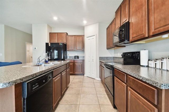 kitchen featuring lofted ceiling, a center island with sink, black appliances, sink, and light tile patterned flooring