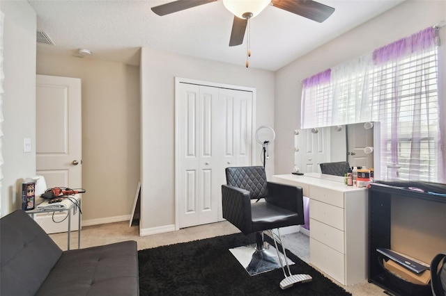 carpeted home office featuring ceiling fan