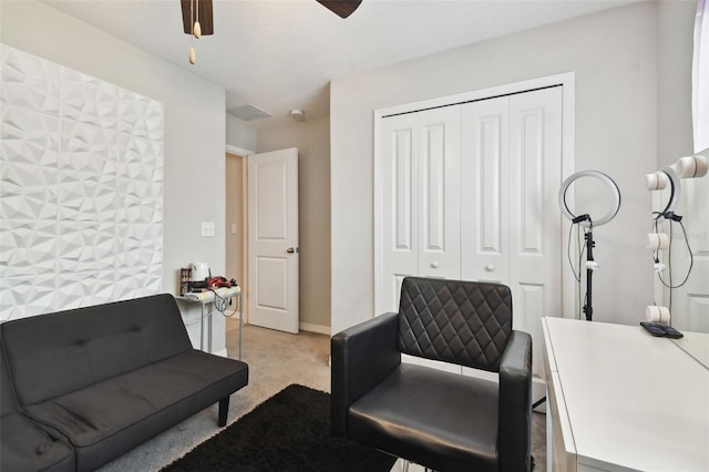 living area with light carpet and ceiling fan