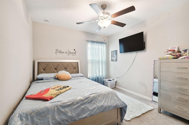 bedroom with a textured ceiling, light colored carpet, and ceiling fan