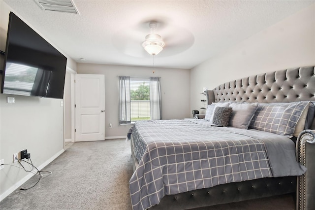 carpeted bedroom featuring a textured ceiling and ceiling fan