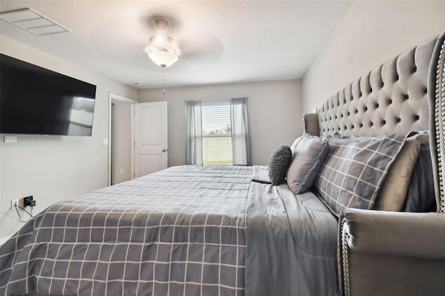 bedroom with ceiling fan and a textured ceiling