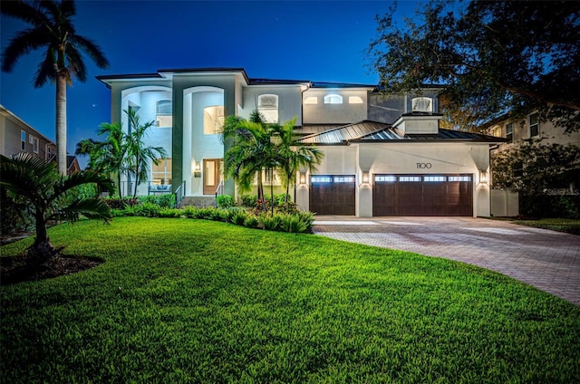 view of front facade with a garage and a lawn