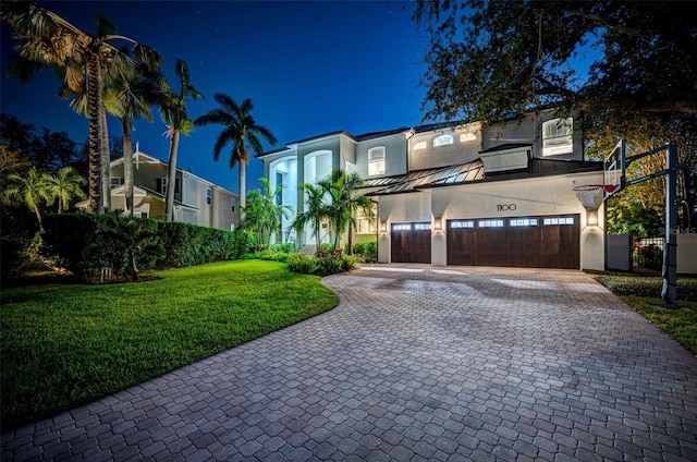 view of front of house featuring a garage and a lawn