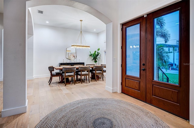 foyer entrance featuring light hardwood / wood-style floors and french doors