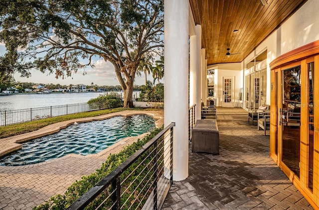 exterior space with a fenced in pool, french doors, and a water view