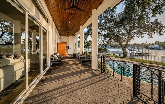 balcony with a water view and ceiling fan