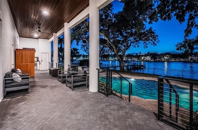 exterior space with a fenced in pool, a water view, outdoor lounge area, and ceiling fan