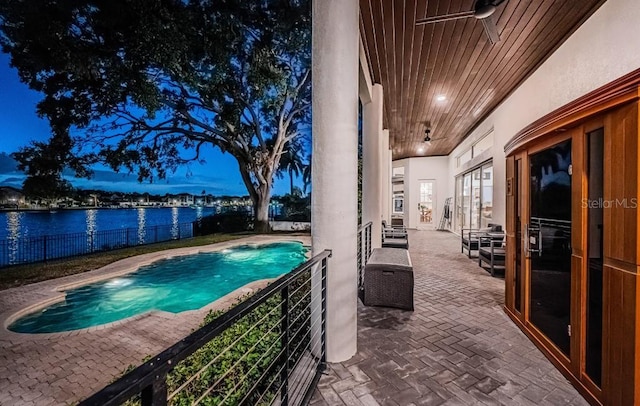 view of pool featuring a patio area, french doors, ceiling fan, and a water view