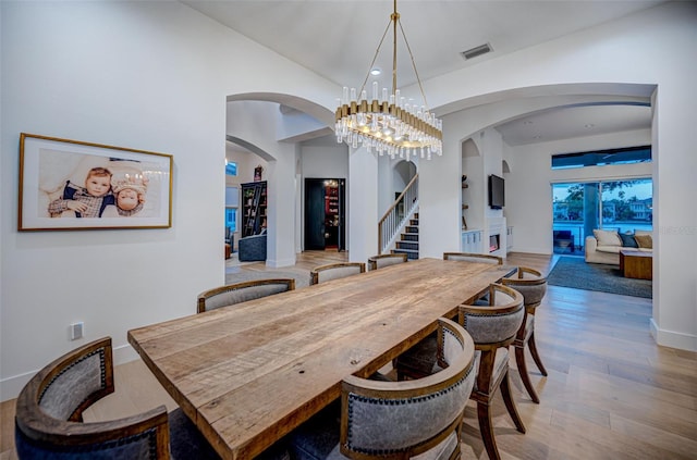 dining area featuring lofted ceiling, hardwood / wood-style floors, and a chandelier