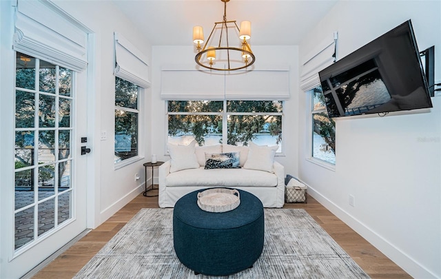 sunroom / solarium with plenty of natural light and a notable chandelier