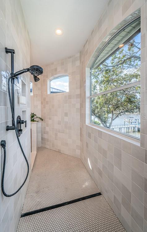 bathroom with tile patterned floors and tiled shower