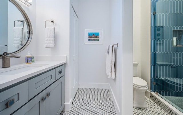 bathroom with vanity, toilet, and a tile shower