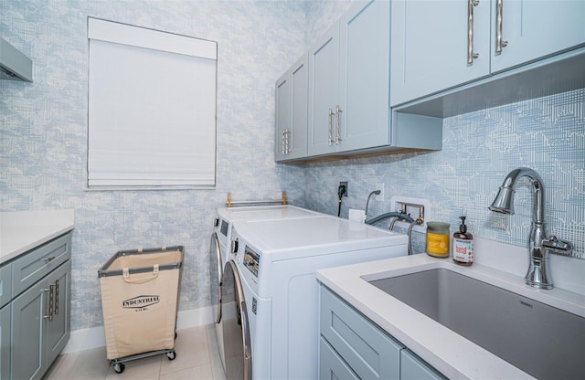 laundry room with cabinets, sink, washer and dryer, and light tile patterned floors