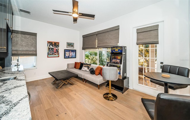 living room featuring plenty of natural light, light hardwood / wood-style floors, and ceiling fan