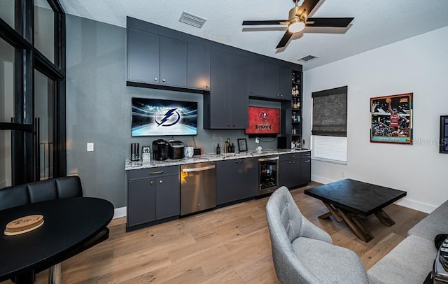 bar featuring a textured ceiling, stainless steel dishwasher, wine cooler, and light hardwood / wood-style floors