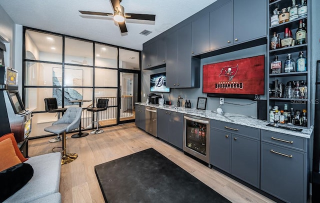 bar with light hardwood / wood-style flooring, blue cabinetry, expansive windows, stainless steel dishwasher, and beverage cooler