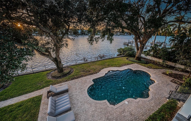 view of swimming pool with a water view, a yard, and a patio