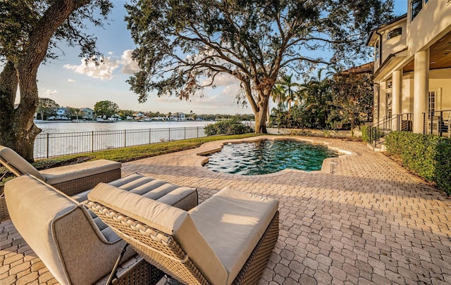 view of pool featuring a patio area and a water view