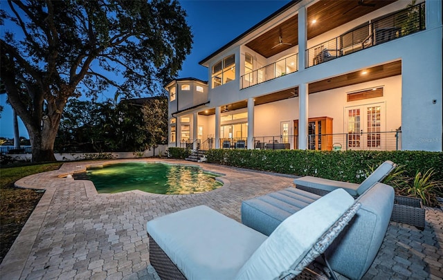 back of property with a fenced in pool, a patio area, outdoor lounge area, and a balcony