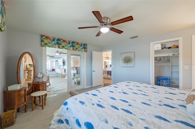 bedroom featuring ceiling fan, ensuite bath, light wood-type flooring, and a closet