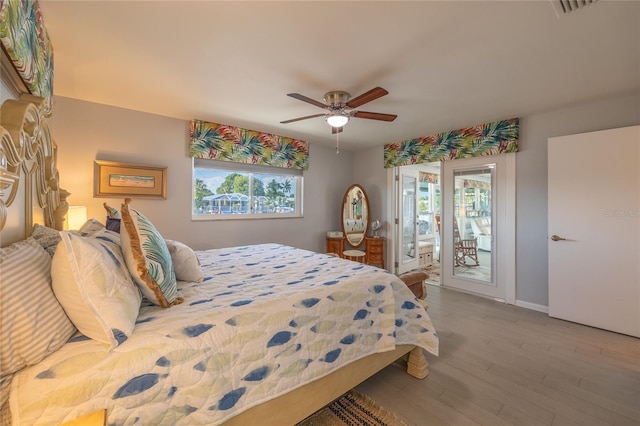 bedroom with hardwood / wood-style floors, ceiling fan, access to exterior, and multiple windows