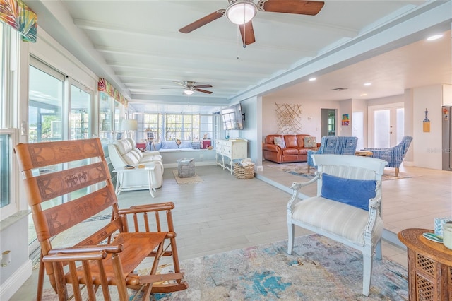 sunroom featuring beam ceiling and ceiling fan